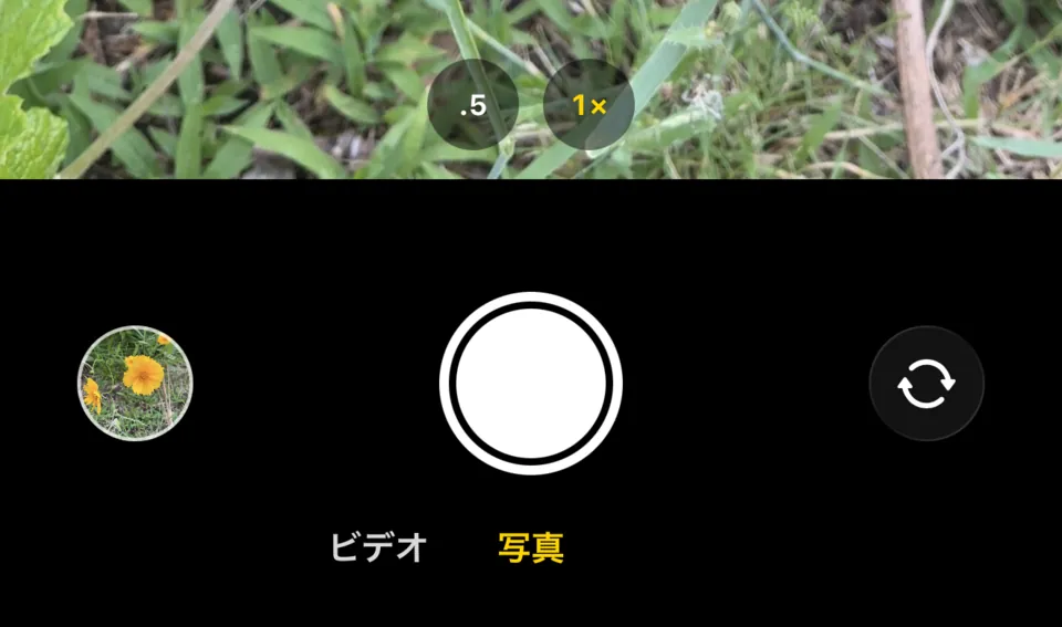 撮影画面の下部。ズームの.5と1×、丸いサムネイル、シャッター、カメラの切り替えボタン、その下にビデオと写真の切り替えがあります。